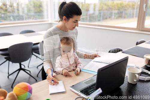 Image of mother with baby working at home office