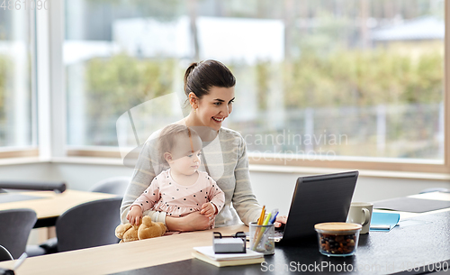 Image of mother with baby and laptop working at home office