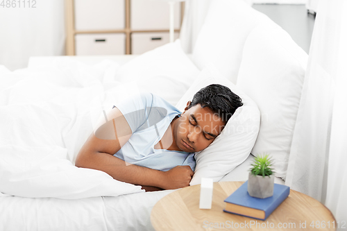 Image of indian man sleeping in bed at home