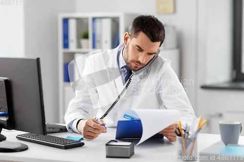 Image of male doctor calling on desk phone at hospital