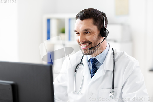 Image of happy doctor with computer and headset at hospital