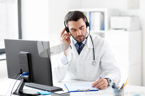 Image of male doctor with headset and clipboard at hospital