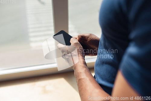 Image of Close up of african-american male hands, working in office