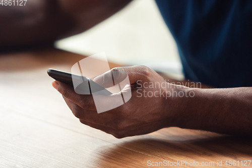 Image of Close up of african-american male hands, working in office