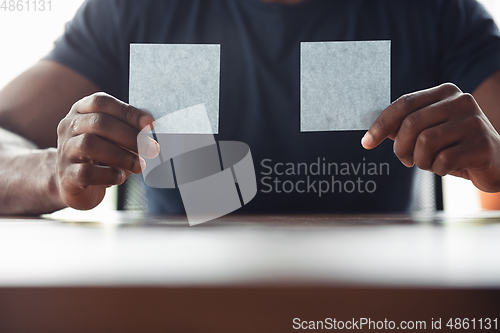 Image of Close up of african-american male hands, working in office