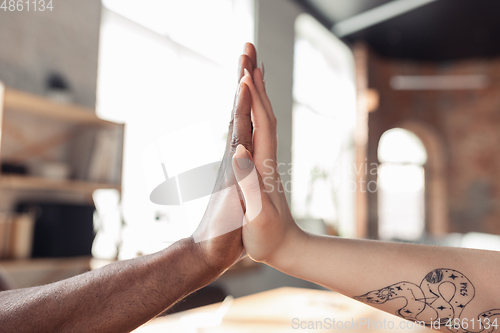 Image of Close up of african-american male and caucasian female hands, working in office