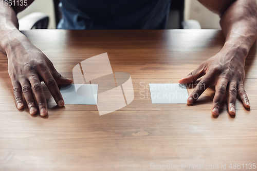 Image of Close up of african-american male hands, working in office
