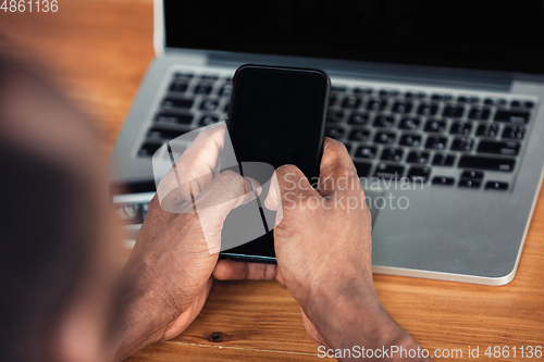 Image of Close up of african-american male hands, working in office