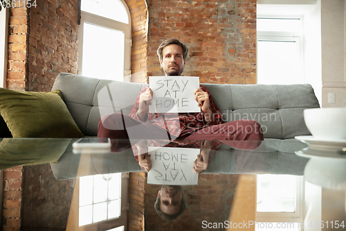 Image of Caucasian man staying at home during quarantine because of coronavirus spreading