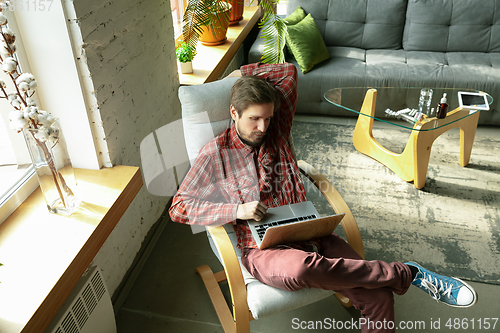 Image of Caucasian man staying at home during quarantine because of coronavirus spreading