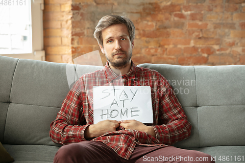 Image of Caucasian man staying at home during quarantine because of coronavirus spreading