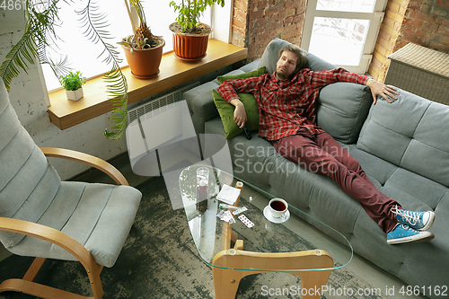 Image of Caucasian man staying at home during quarantine because of coronavirus spreading