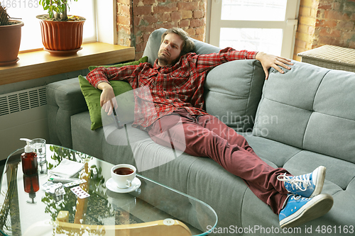 Image of Caucasian man staying at home during quarantine because of coronavirus spreading