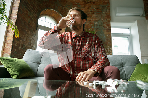 Image of Caucasian man staying at home during quarantine because of coronavirus spreading