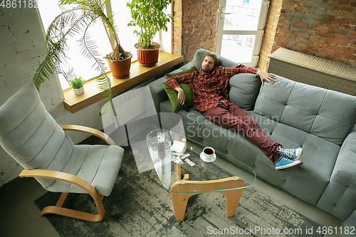 Image of Caucasian man staying at home during quarantine because of coronavirus spreading