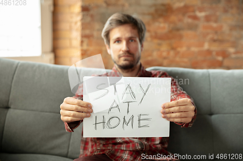 Image of Caucasian man staying at home during quarantine because of coronavirus spreading