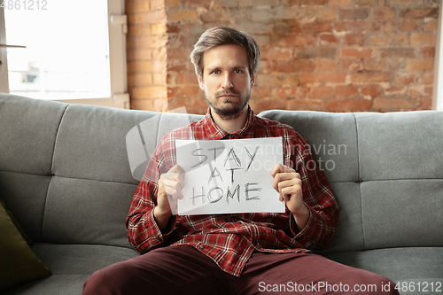 Image of Caucasian man staying at home during quarantine because of coronavirus spreading