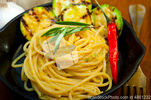 Image of italian spaghetti pasta with zucchini sauce on iron skillet