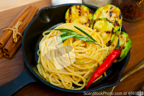 Image of italian spaghetti pasta with zucchini sauce on iron skillet