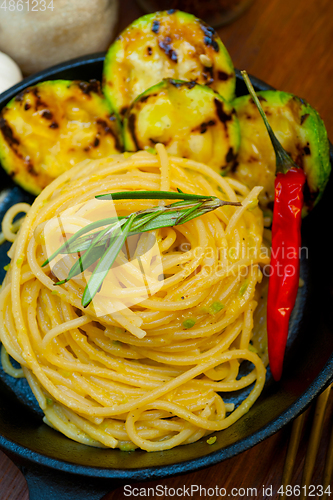 Image of italian spaghetti pasta with zucchini sauce on iron skillet