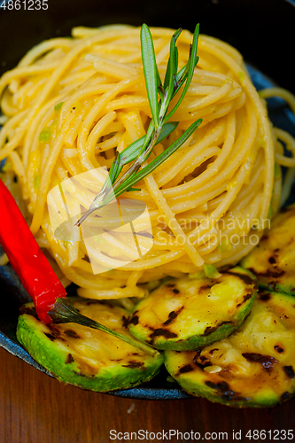 Image of italian spaghetti pasta with zucchini sauce on iron skillet