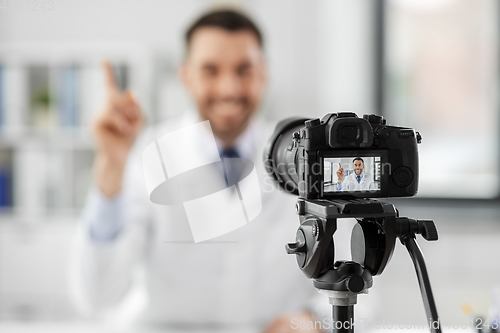 Image of male doctor recording video blog at hospital