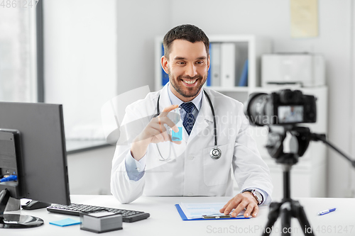 Image of doctor with hand sanitizer recording video blog