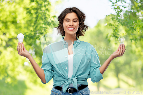 Image of smiling woman comparing different light bulbs