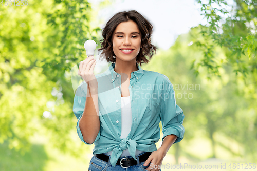 Image of smiling woman holding energy saving lighting bulb