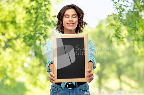 Image of portrait of smiling woman showing black chalkboard