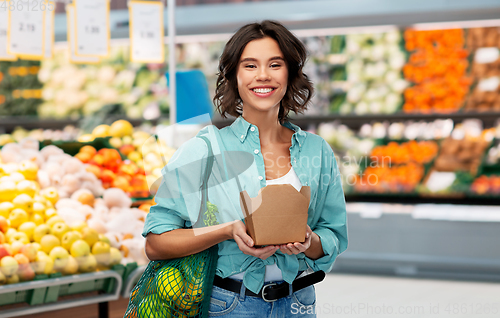 Image of happy woman with food in reusable net bag and wok