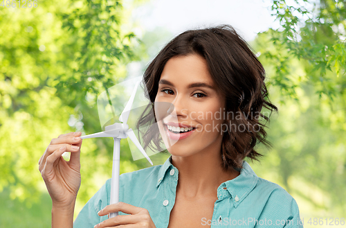 Image of happy smiling young woman with toy wind turbine