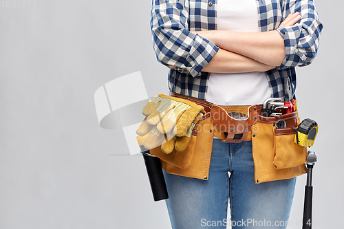 Image of woman or builder with working tools on belt