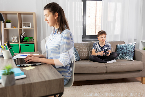 Image of boy with gamepad playing video game at home