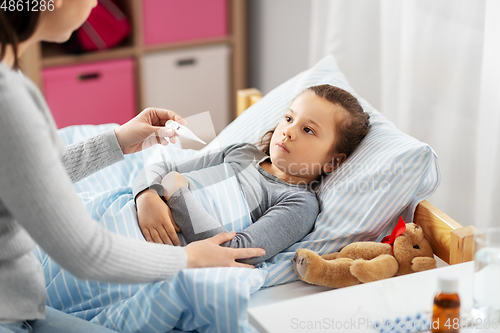 Image of mother measuring temperature of sick daughter