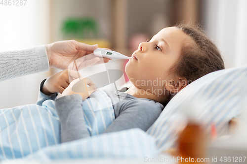 Image of mother and sick daughter measuring temperature