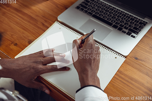 Image of African-american doctor consulting for patient, working in cabinet, close up