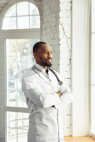 Image of African-american doctor consulting, working in cabinet, close up