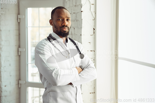 Image of African-american doctor consulting, working in cabinet, close up