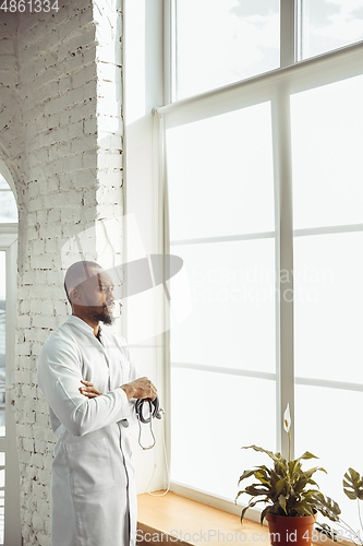 Image of African-american doctor consulting, working in cabinet, close up