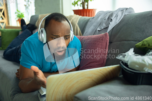 Image of African-american man staying at home during quarantine because of coronavirus spreading