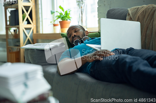 Image of African-american man staying at home during quarantine because of coronavirus spreading