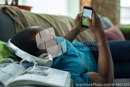 Image of African-american man staying at home during quarantine because of coronavirus spreading