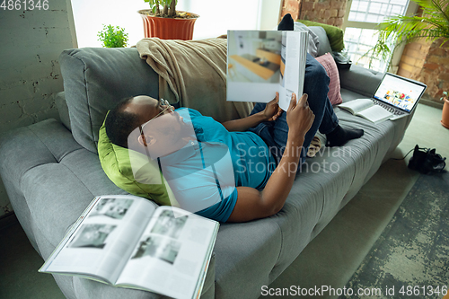 Image of African-american man staying at home during quarantine because of coronavirus spreading