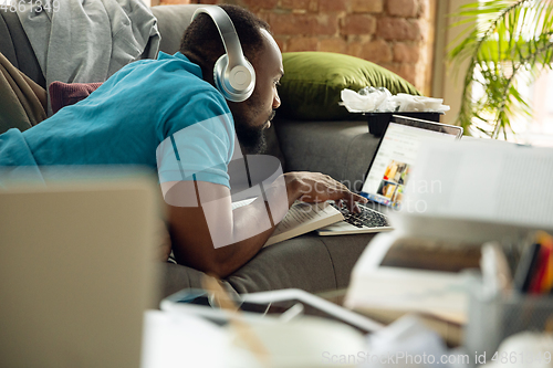 Image of African-american man staying at home during quarantine because of coronavirus spreading