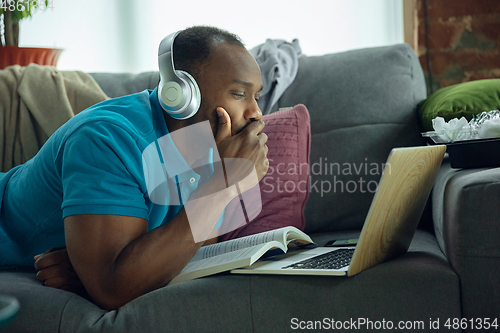 Image of African-american man staying at home during quarantine because of coronavirus spreading