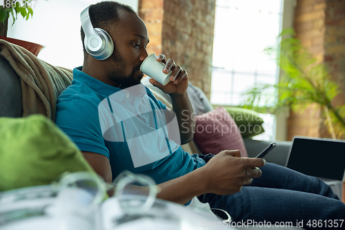 Image of African-american man staying at home during quarantine because of coronavirus spreading