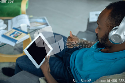 Image of African-american man staying at home during quarantine because of coronavirus spreading