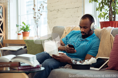 Image of African-american man staying at home during quarantine because of coronavirus spreading