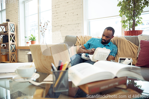 Image of African-american man staying at home during quarantine because of coronavirus spreading